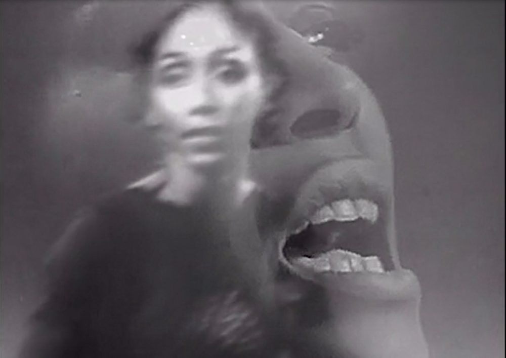 A black and white transparent image of a woman's face. She looks like she is in pain or struggling. Behind this close up image is another image of a woman looking directly at the camera.