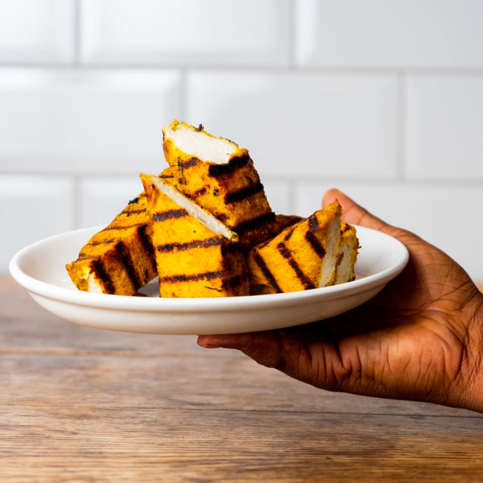 A hand holding out a plate of food